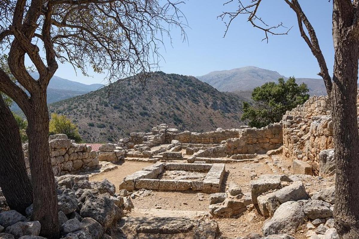 αρχαία ερείπια με δέντρα και βουνά στο φόντο