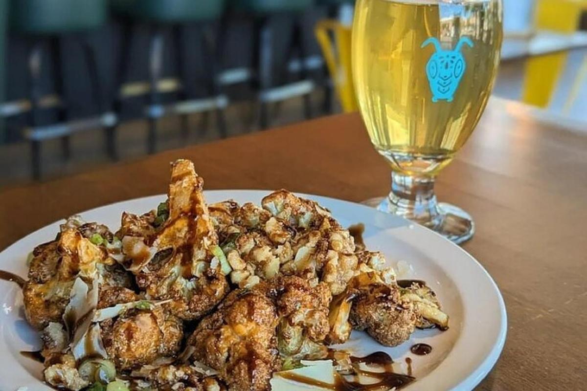 a plate of food and a glass of beer on a table