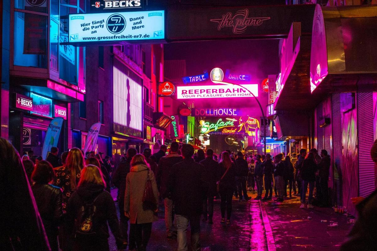 a crowd of people walking down a street at night
