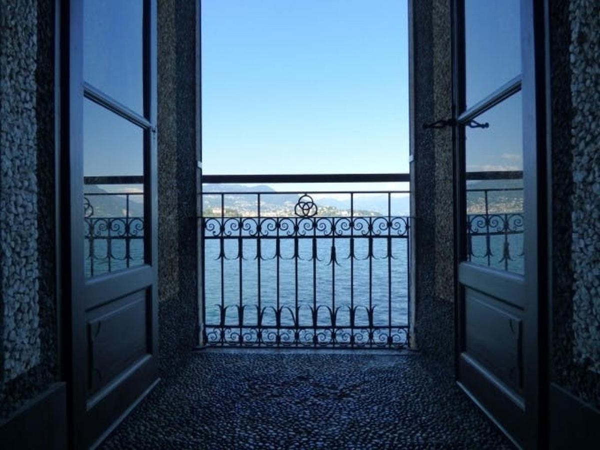 uma porta aberta para uma varanda com vista para o oceano
