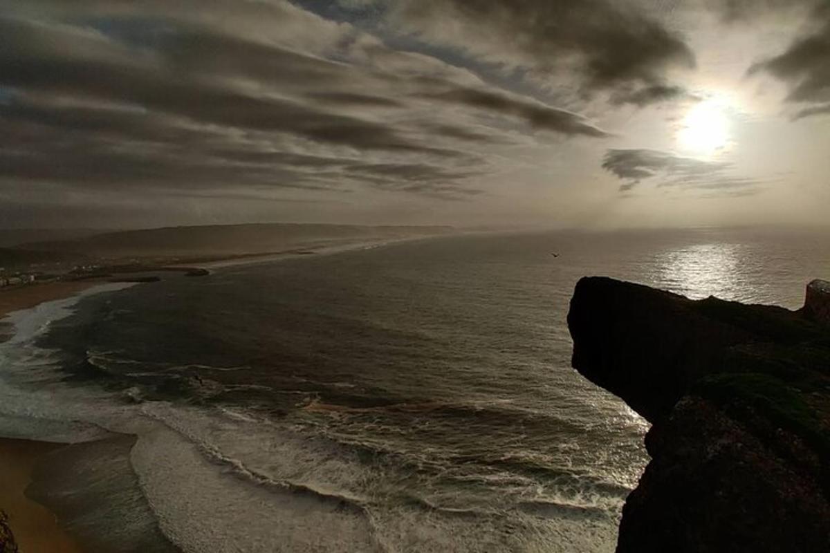 una vista di una spiaggia con il sole e l'oceano