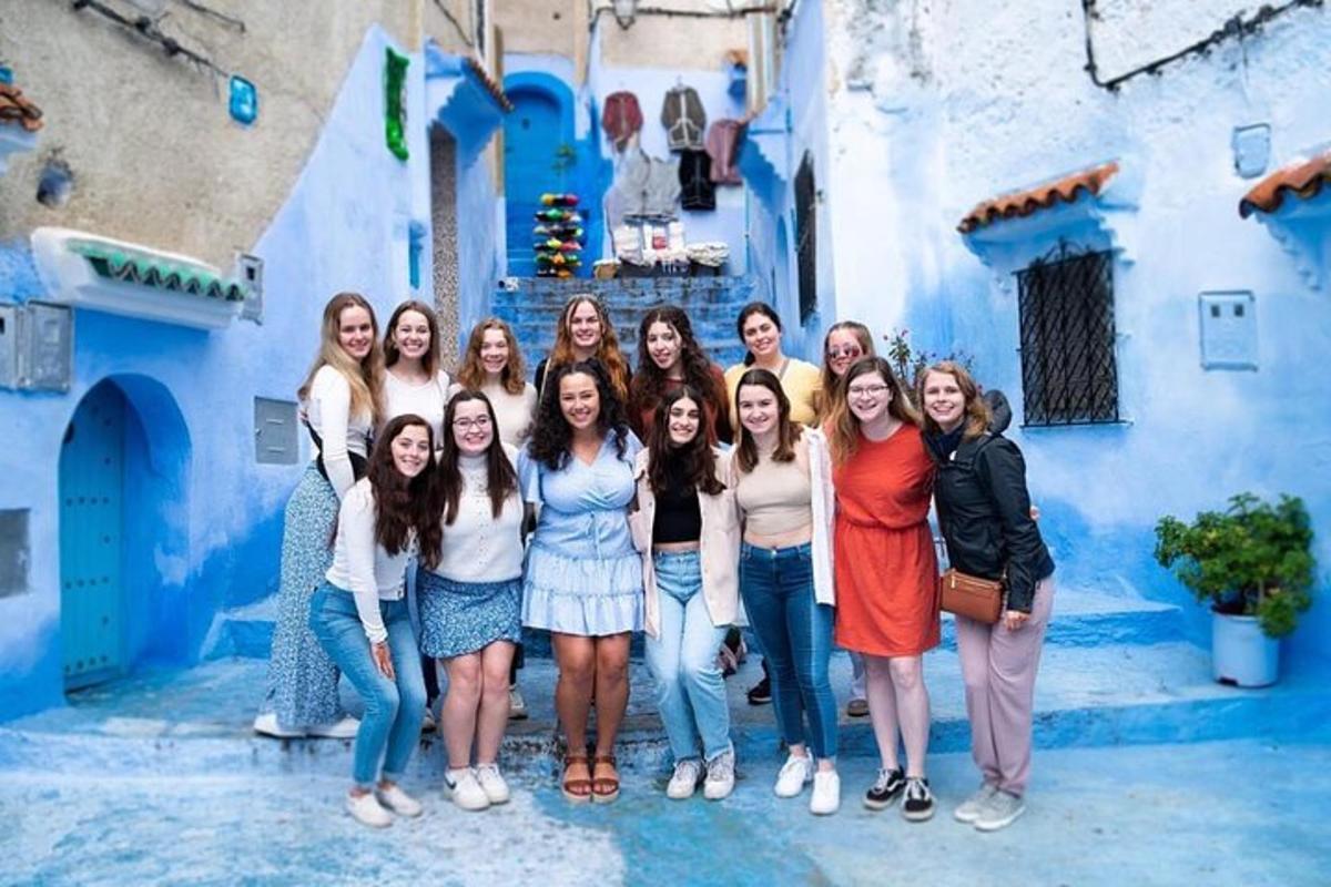 a group of women standing in front of a blue building