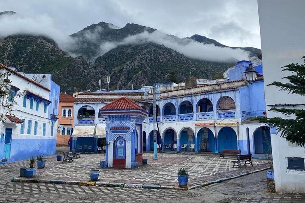 a town with blue buildings and a mountain in the background