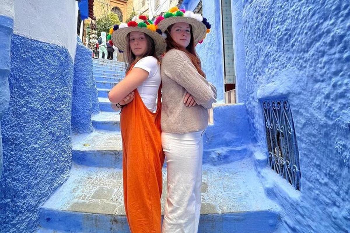 two women standing next to each other on a blue street