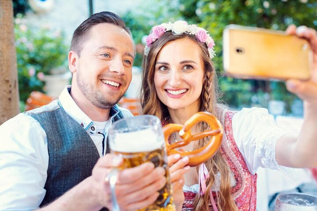 un uomo che scatta una foto a una donna che tiene in mano un boccale di birra