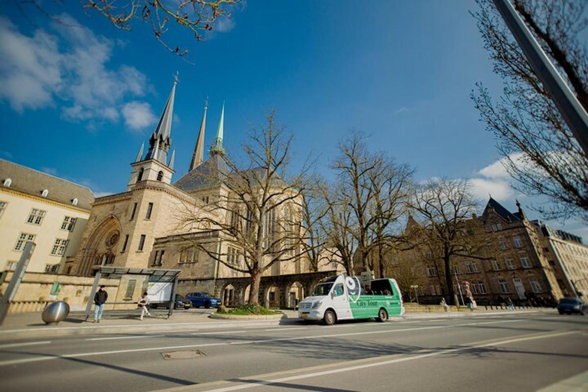 a green car parked in front of a building with a church