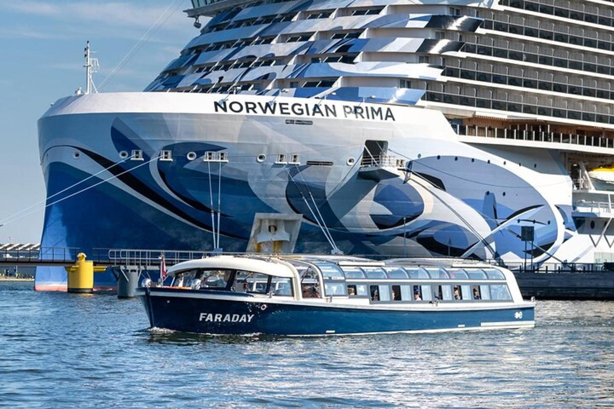 a boat in the water next to a cruise ship