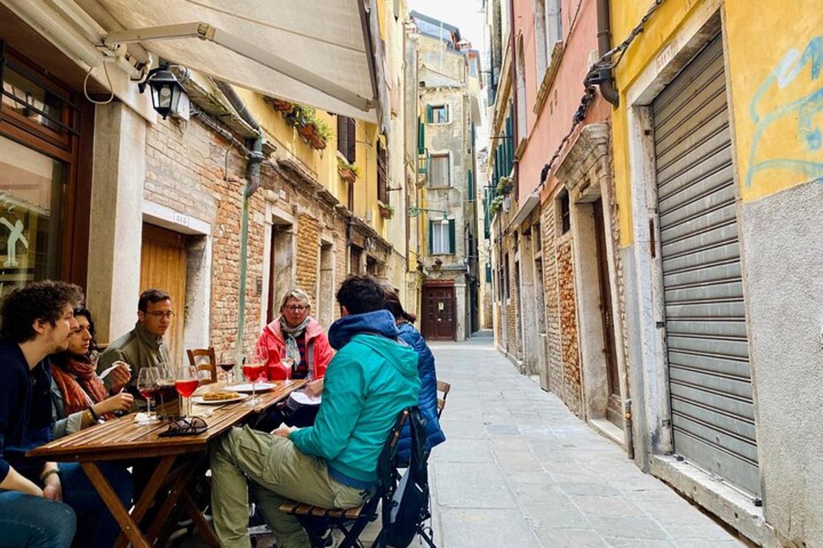 un gruppo di persone sedute a un tavolo in un vicolo
