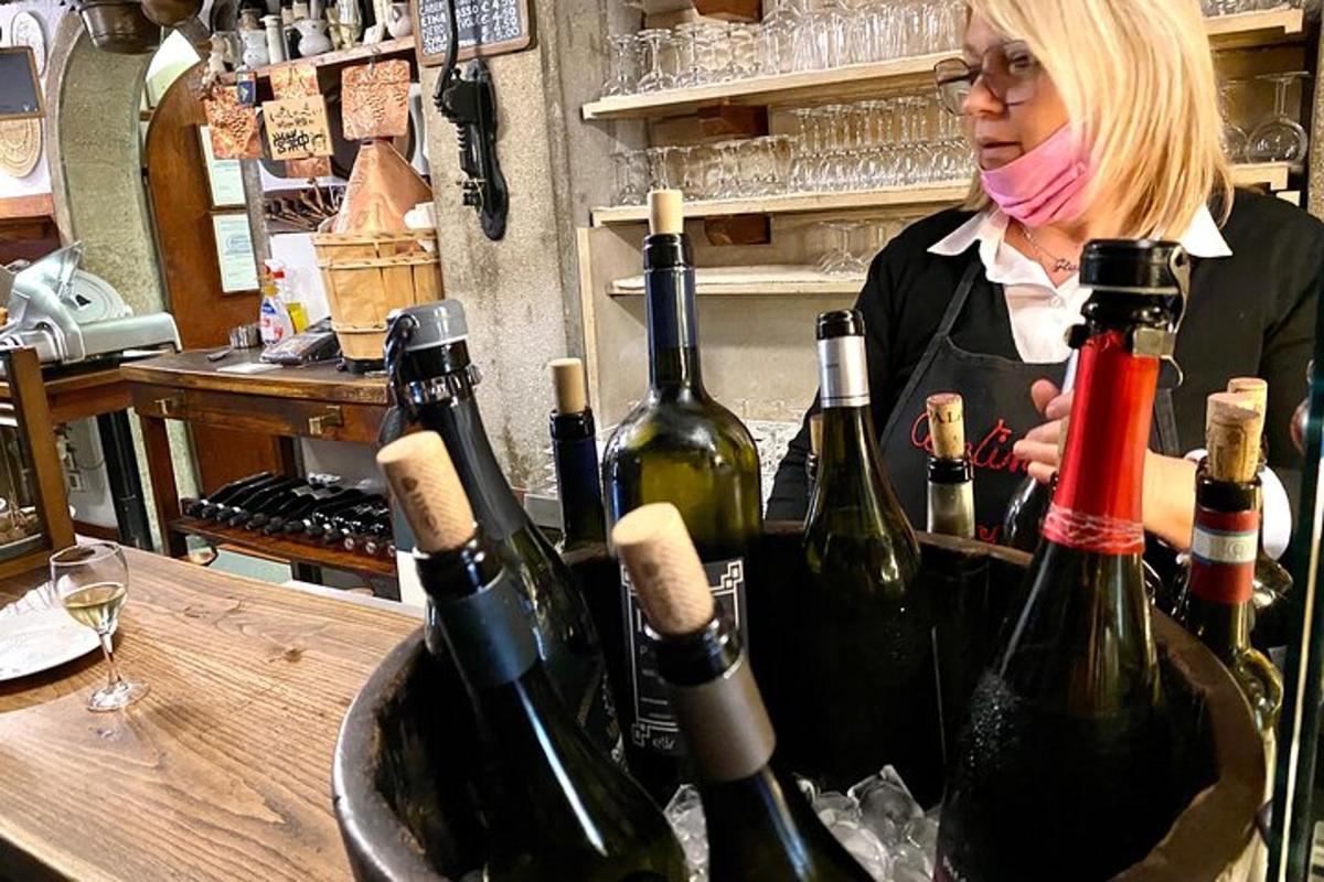 a woman standing behind a bunch of wine bottles