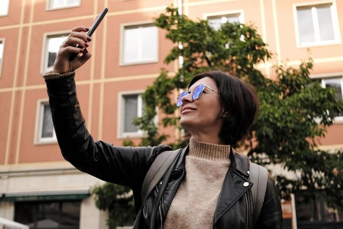 naine, kes hoiab mobiiltelefoni õhus