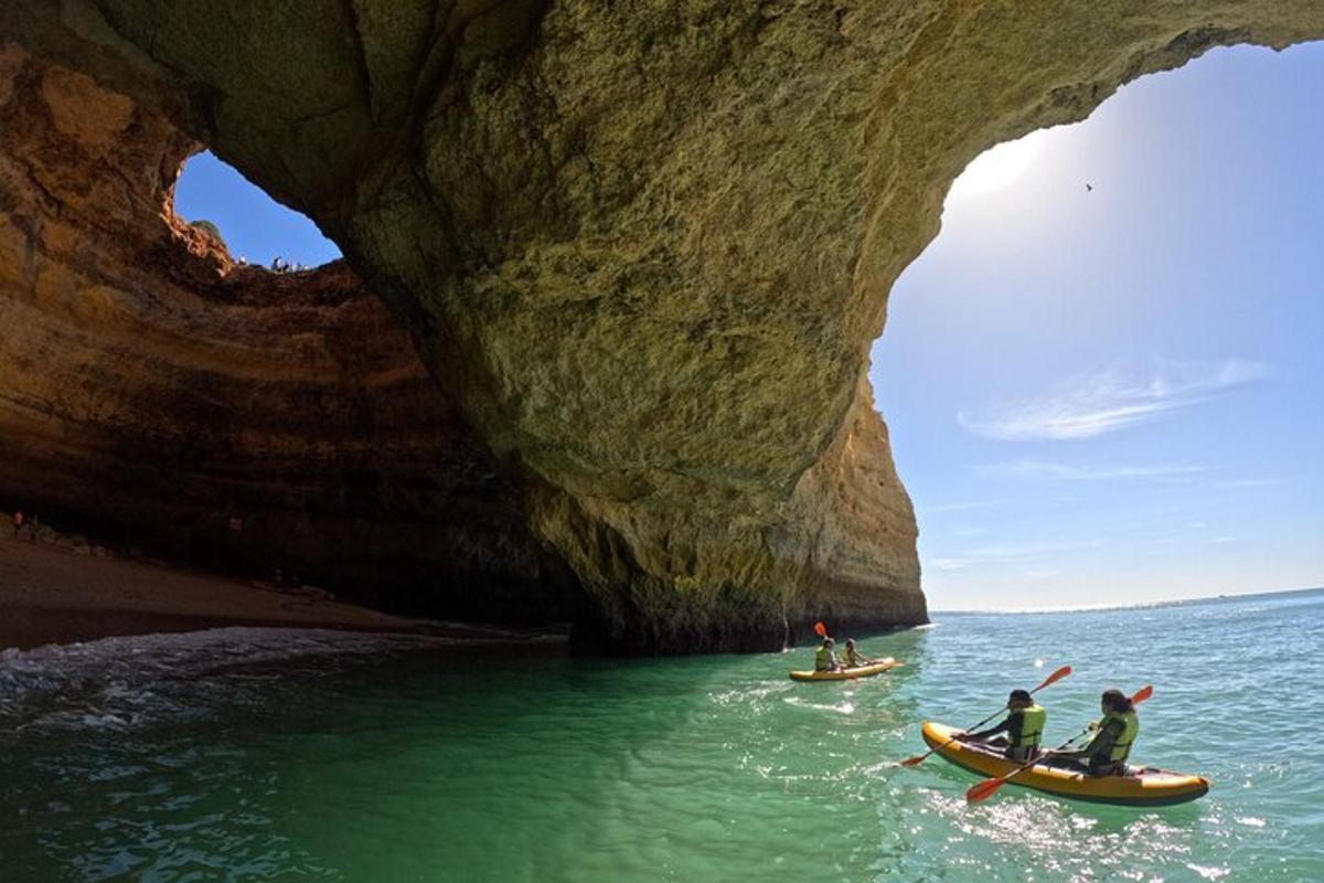 a group of people in kayaks in front of a cave