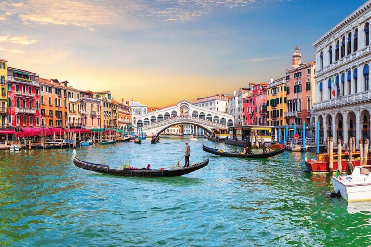 un gruppo di gondole in un canale con un ponte