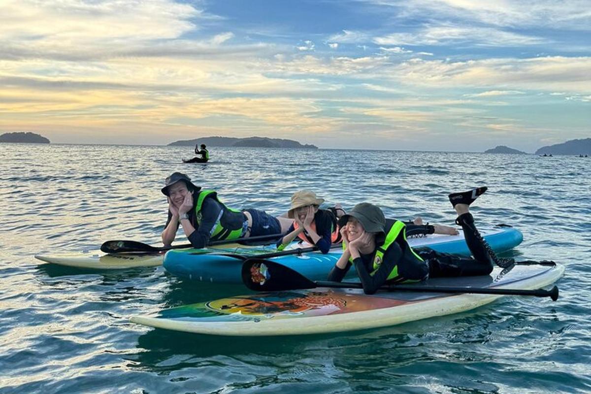 un grup de persones estirades sobre taules de surf a l'aigua