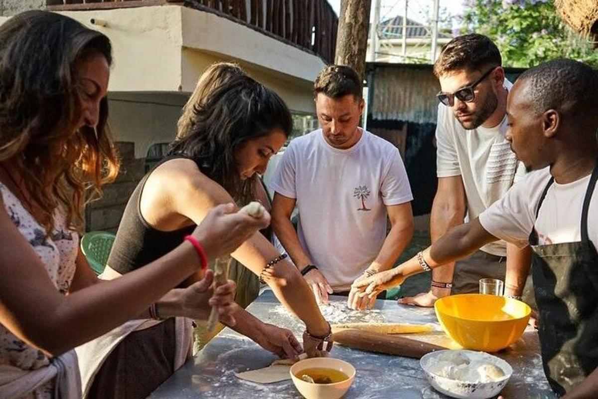Un grupo de personas de pie alrededor de una mesa preparando comida.