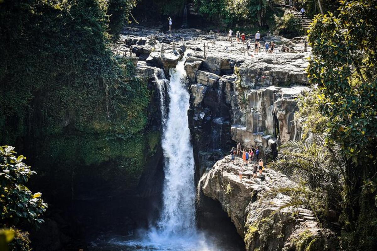 as pessoas estão paradas na base de uma cachoeira