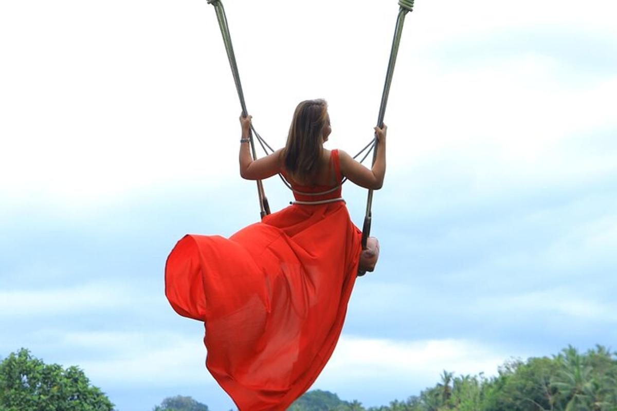 uma mulher de vestido vermelho sentada em um balanço