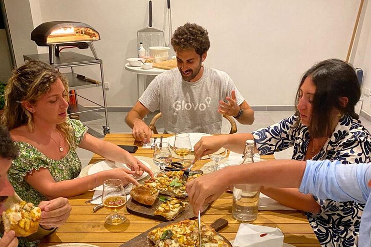 un gruppo di persone sedute attorno a un tavolo che mangiano cibo