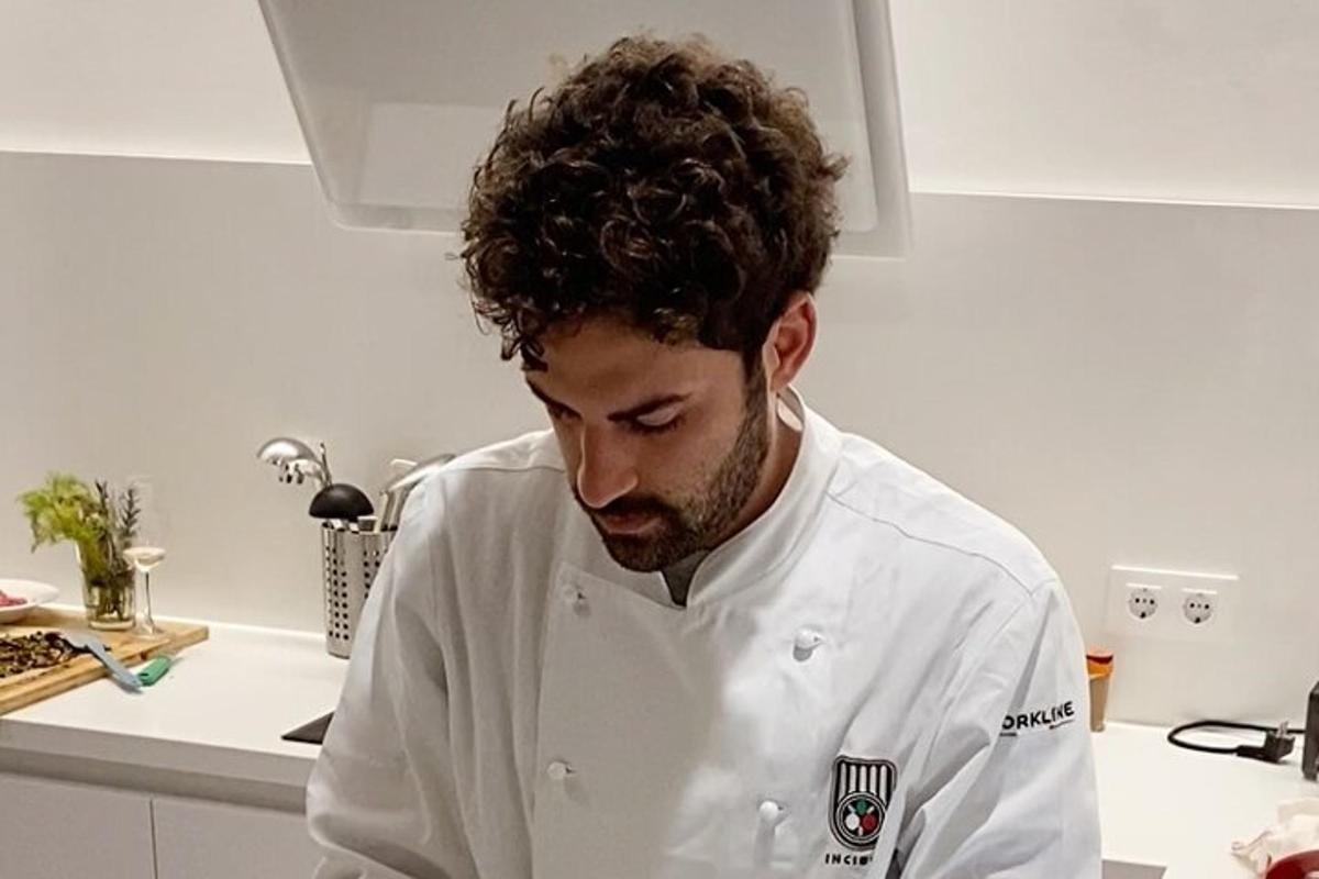 un uomo in cucina che indossa un'uniforme da chef