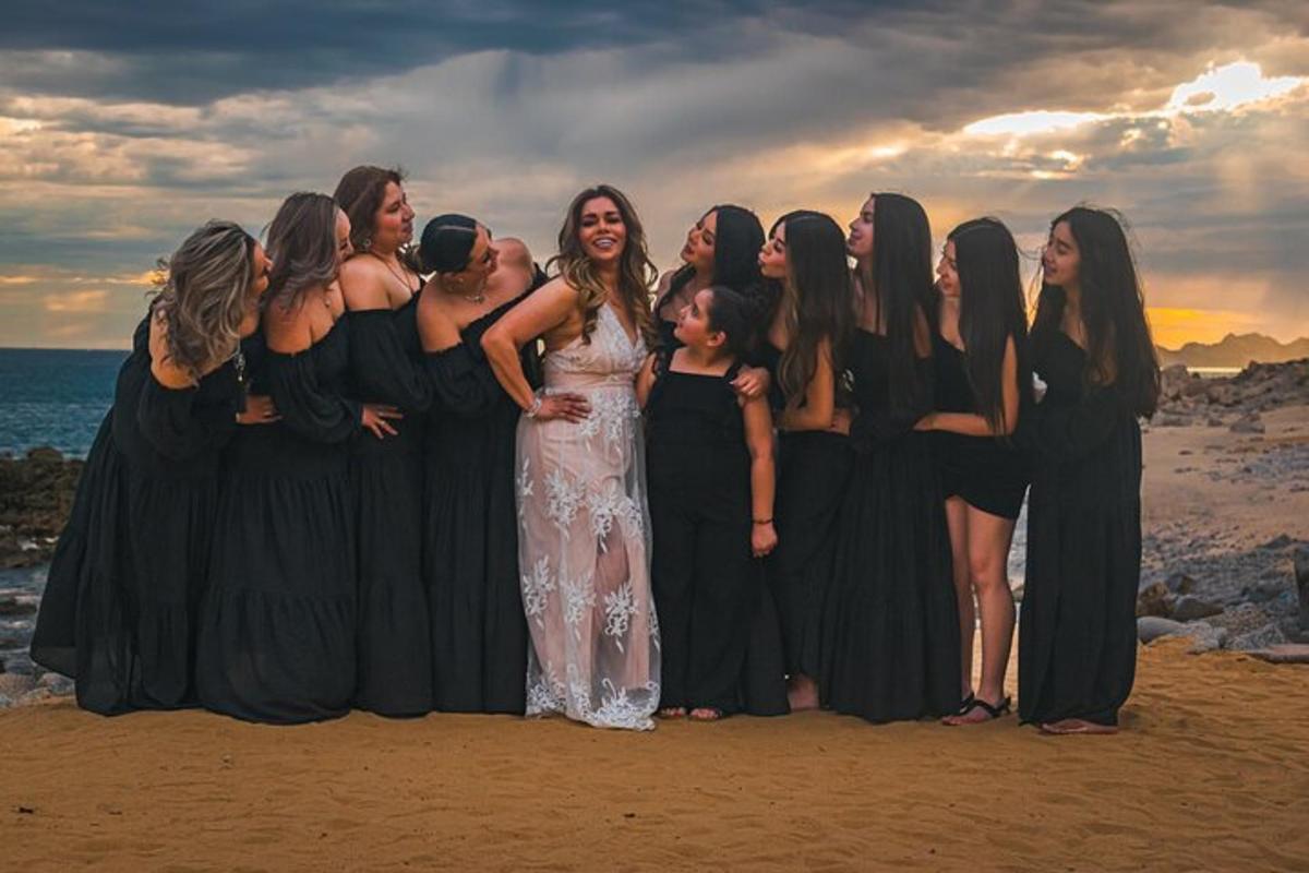 um grupo de mulheres posando para uma foto na praia