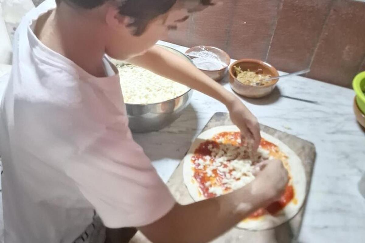 a person making a pizza on a counter