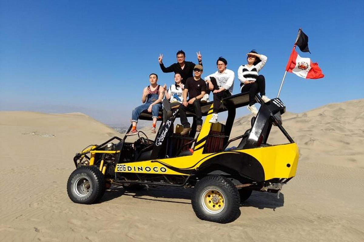 un gruppo di persone sedute in cima a un quad sulla sabbia