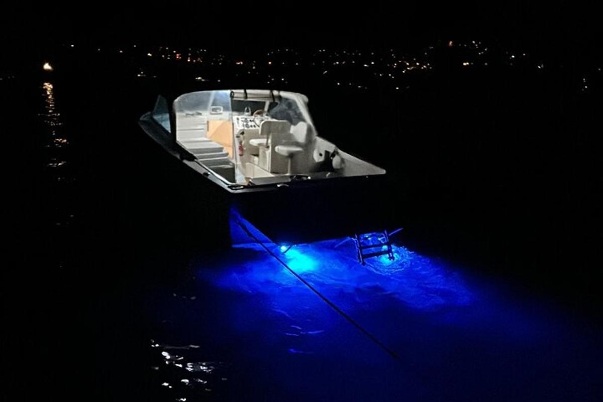 un barco flotando en el agua por la noche