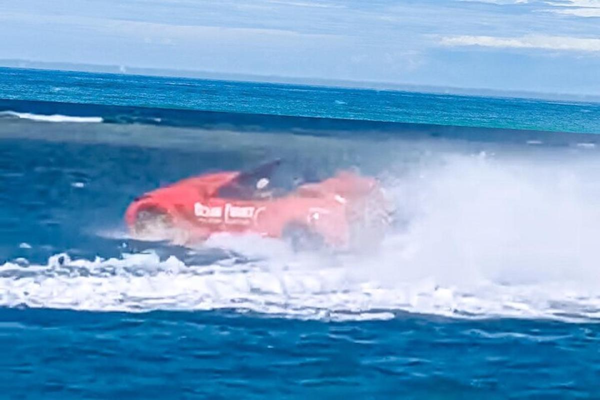 en rød bil i vannet i havet