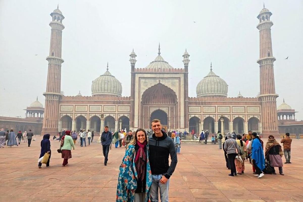a man and woman standing in front of a mosque