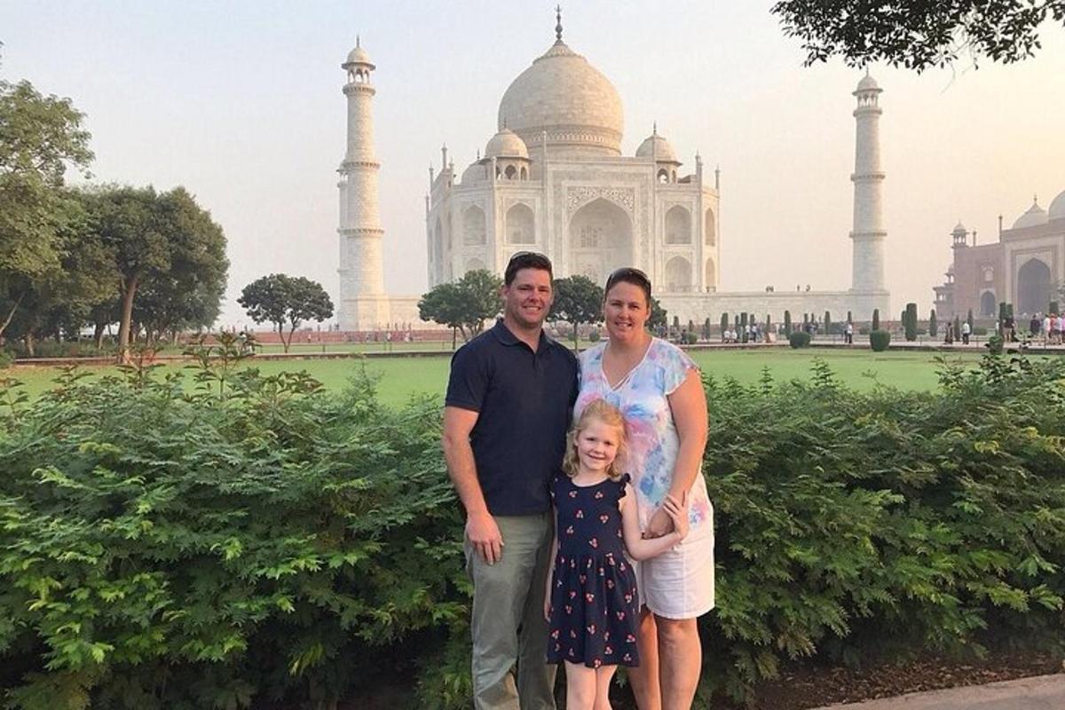 a family posing in front of the taj mahal