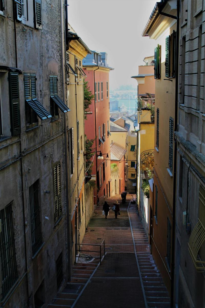 an alley with people walking down a street between buildings
