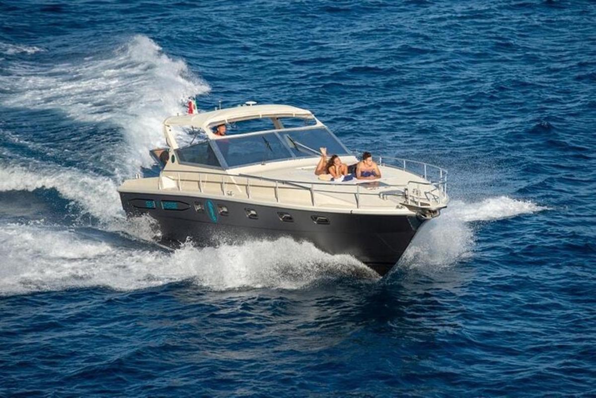zwei Personen und zwei Hunde auf einem Boot im Wasser