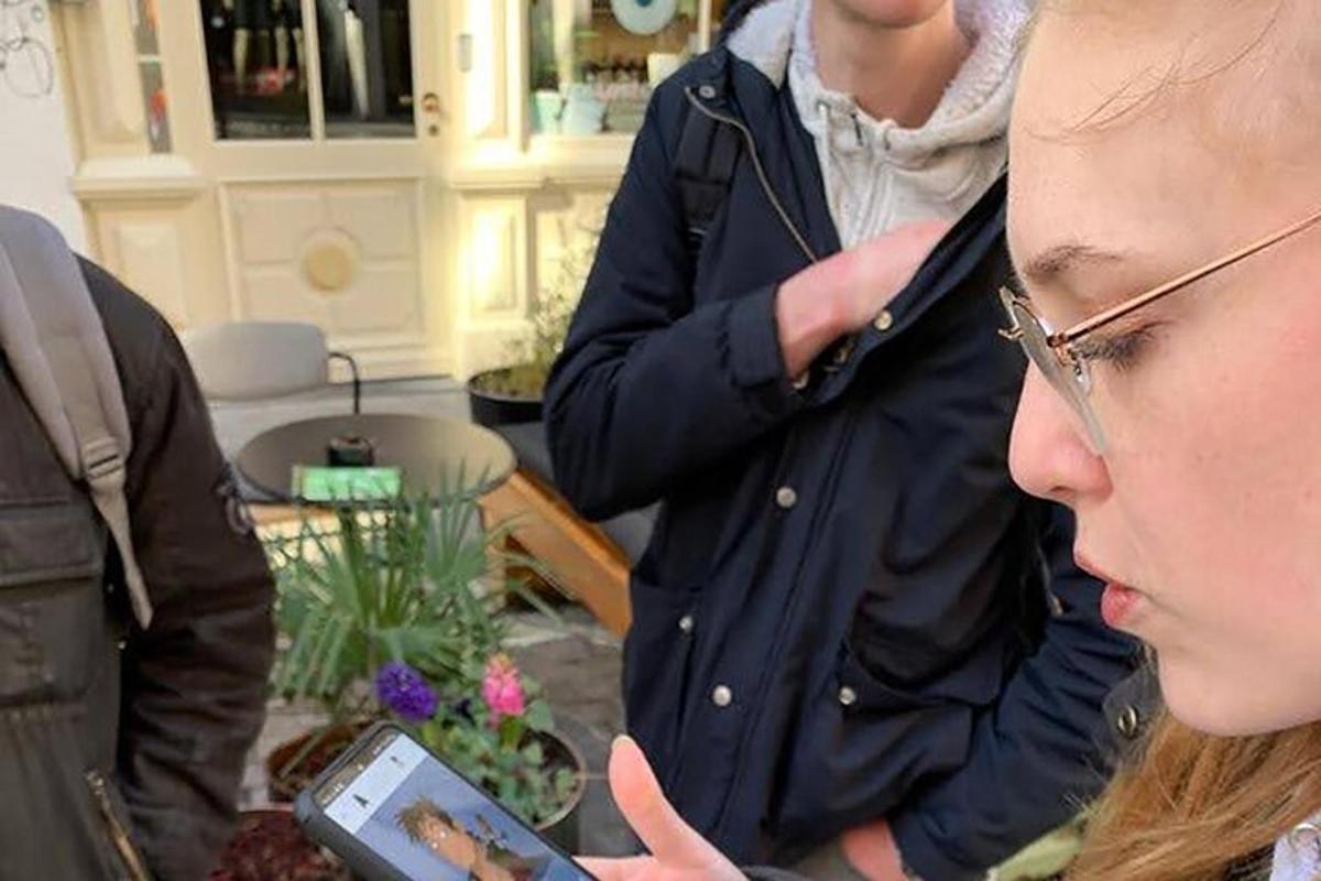μια γυναίκα κοιτάζει ένα κινητό τηλέφωνο