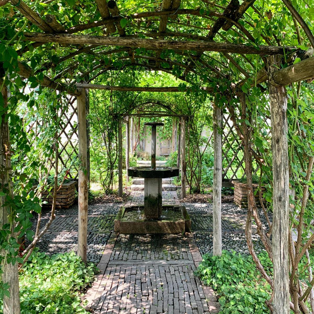 un arc amb una font en un jardí