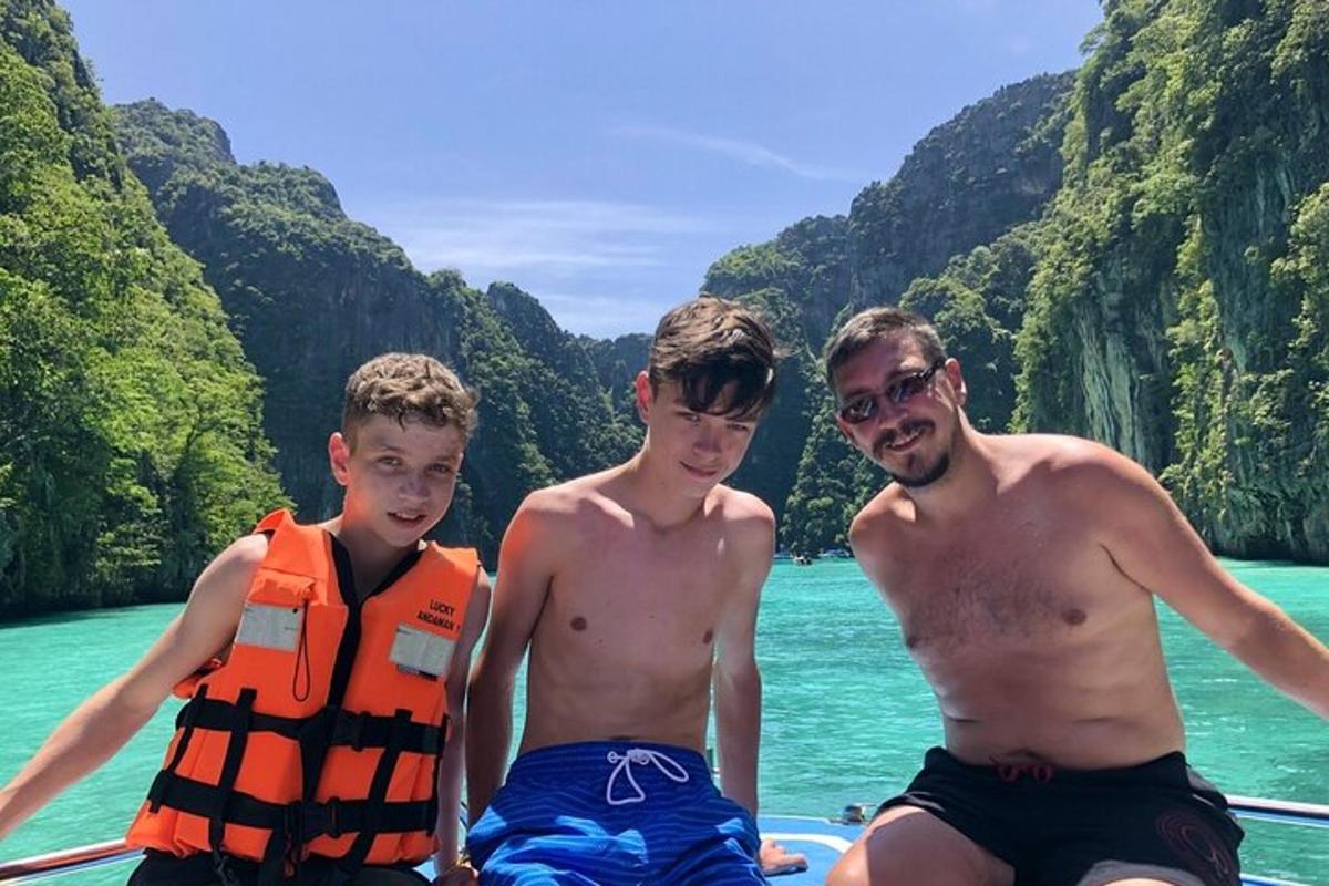 três jovens sentados em um barco na água