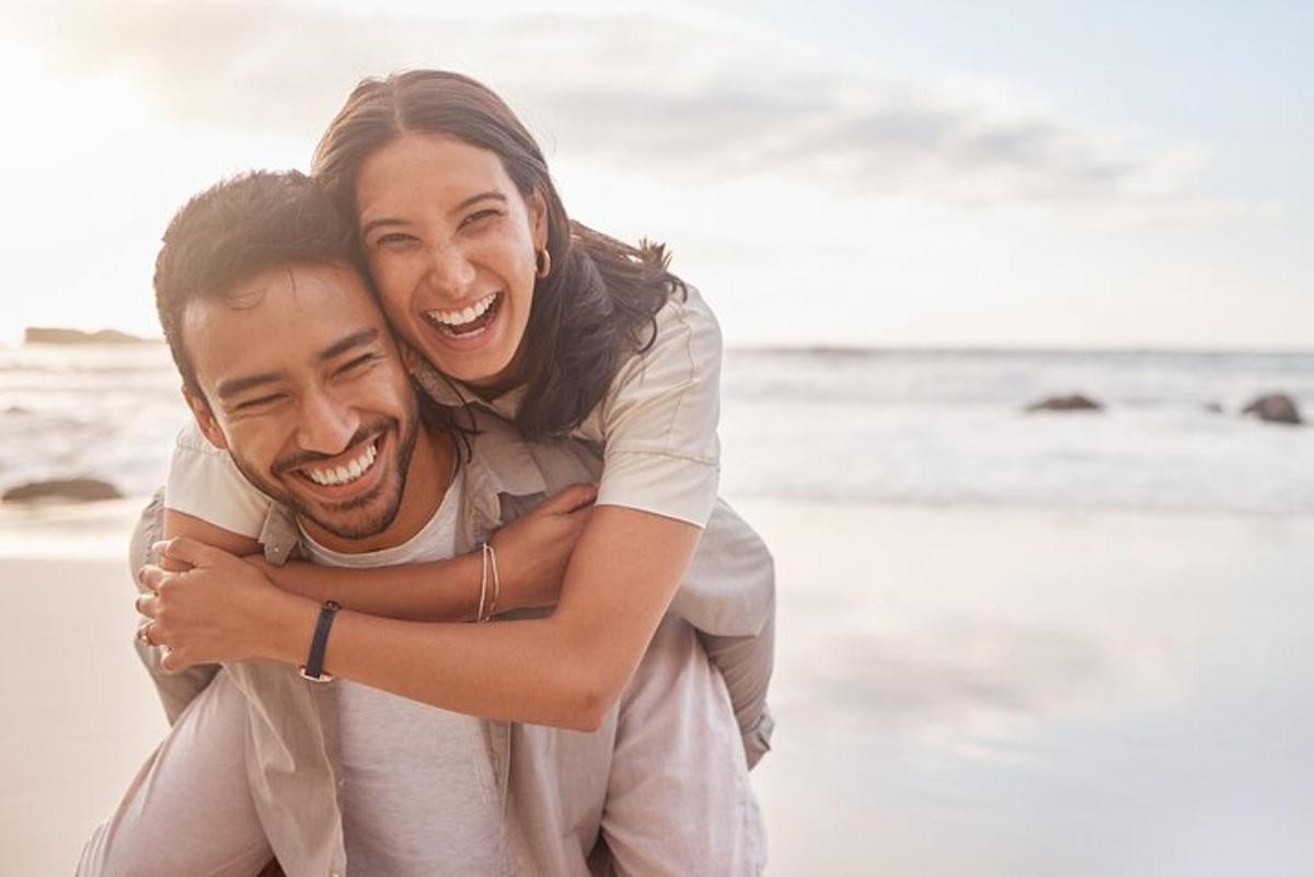 a woman hugging a man on the beach