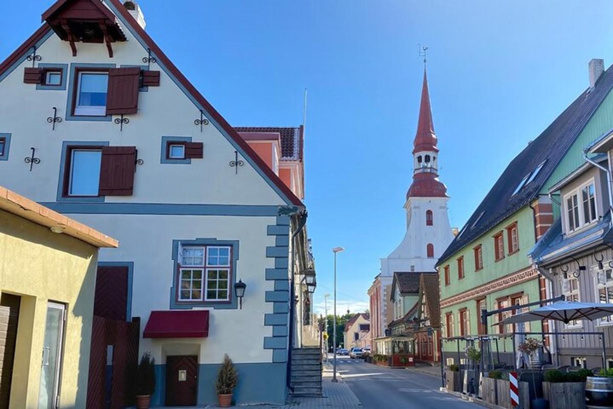 a city street with a white building and a church