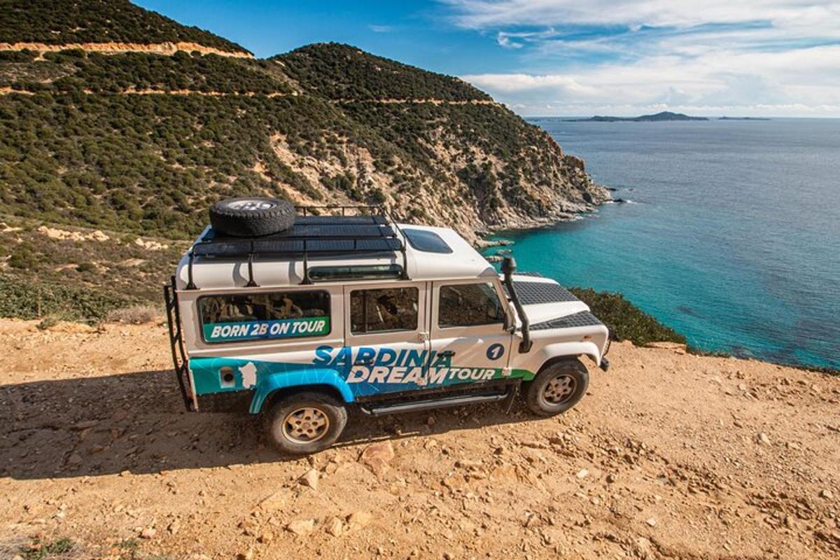 a vehicle parked on a hill next to the ocean
