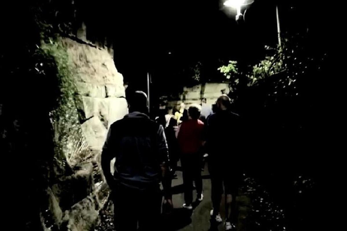grupp inimesi, kes kõnnivad öösel mööda teed