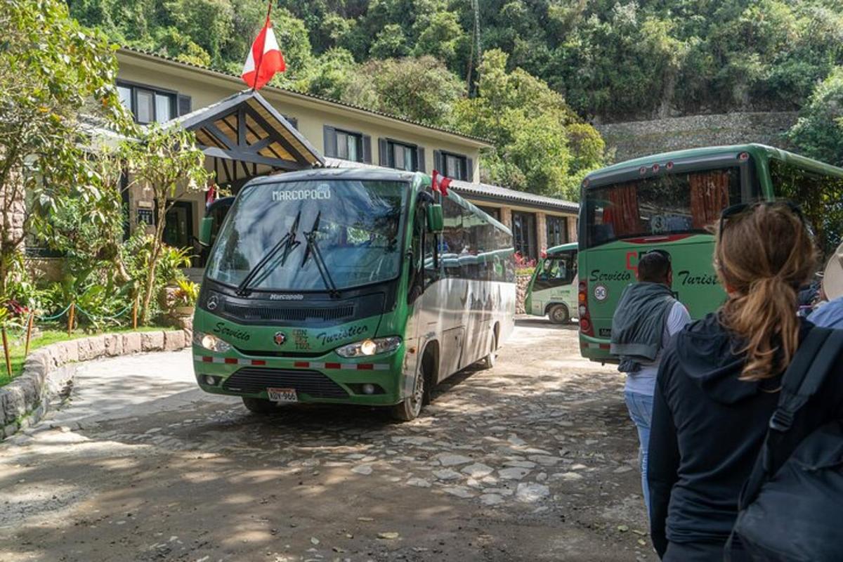 skupina ljudi, ki stojijo ob dveh avtobusih