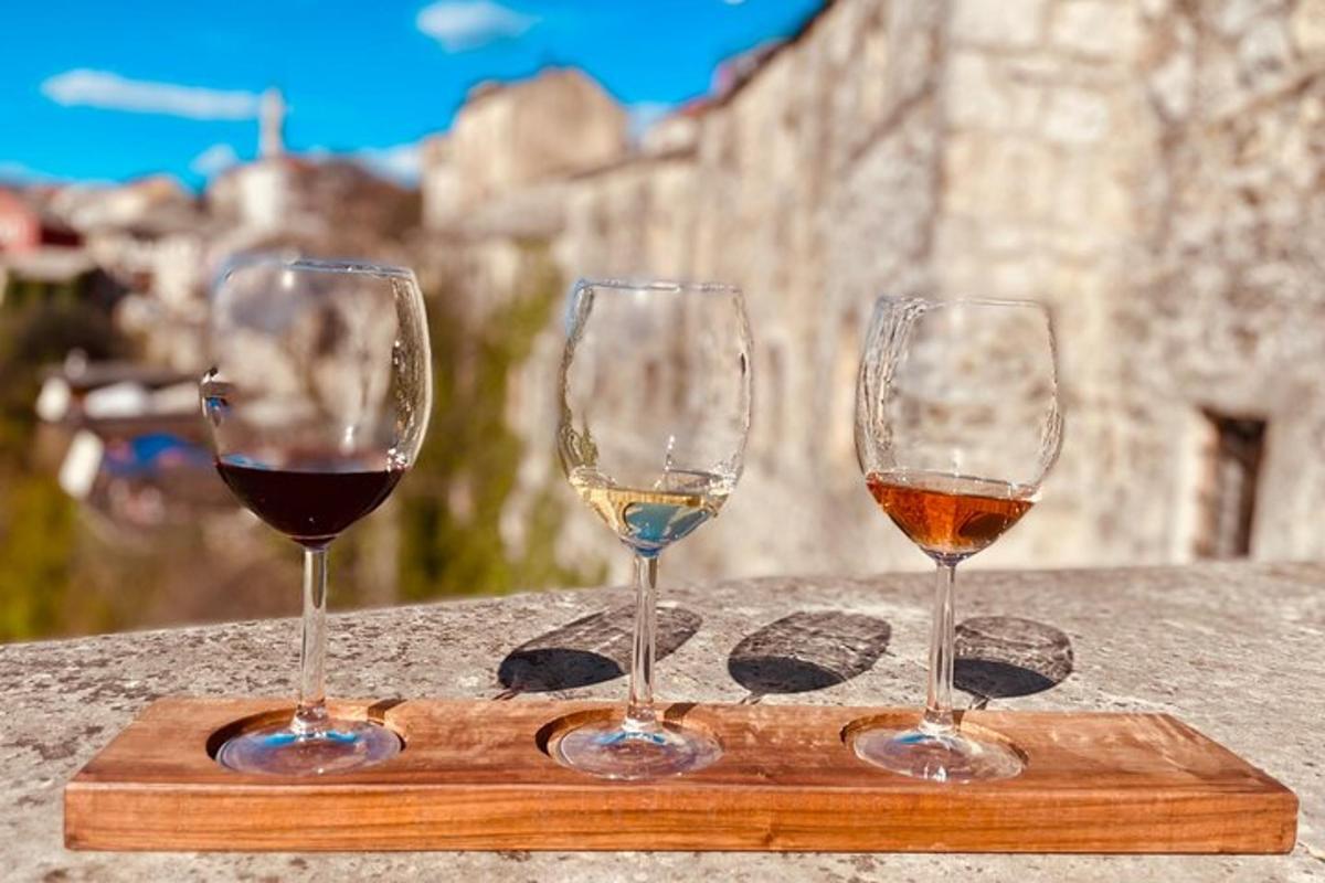 Τρία ποτήρια κρασιού κάθονται σε μια ξύλινη σανίδα κοπής