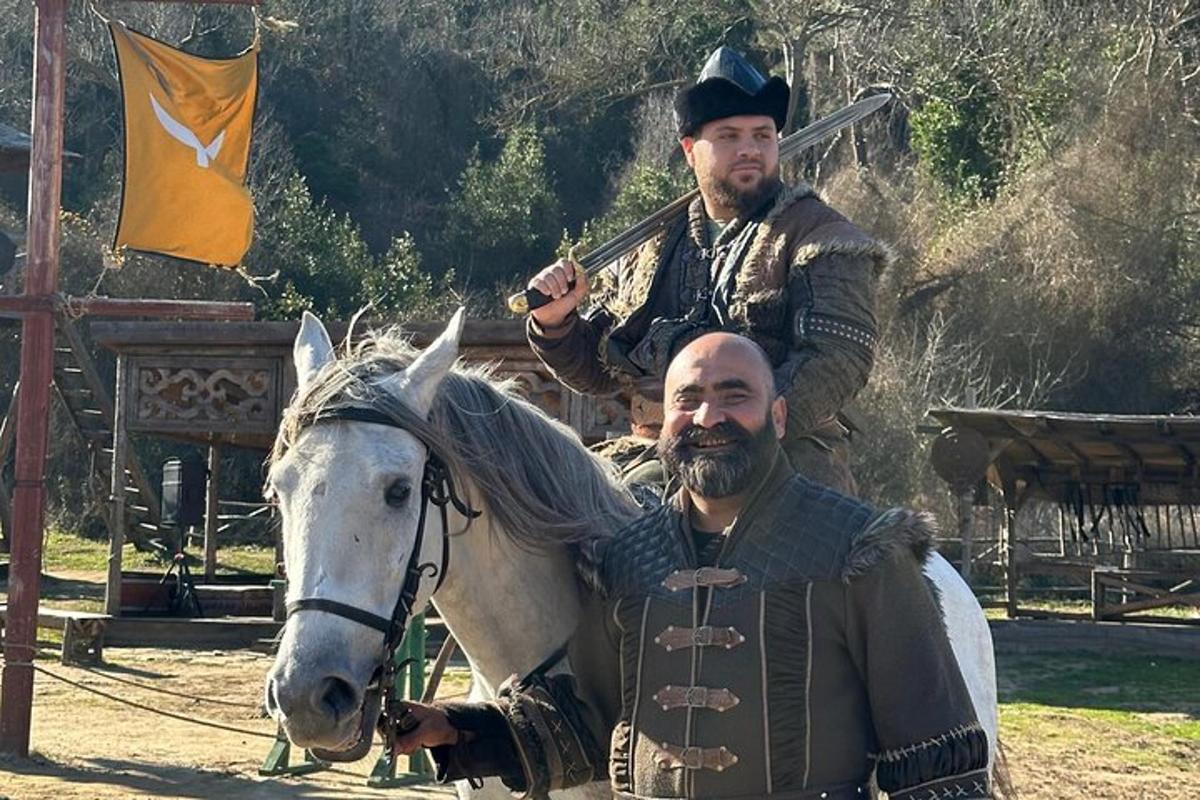 twee mannen in historische kleding op een wit paard