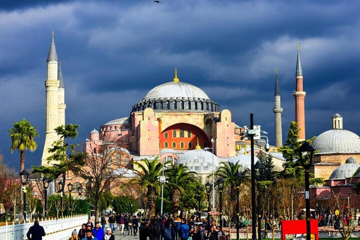 ένα κτίριο με τρούλους και τζαμιά με ανθρώπους να περπατούν μπροστά
