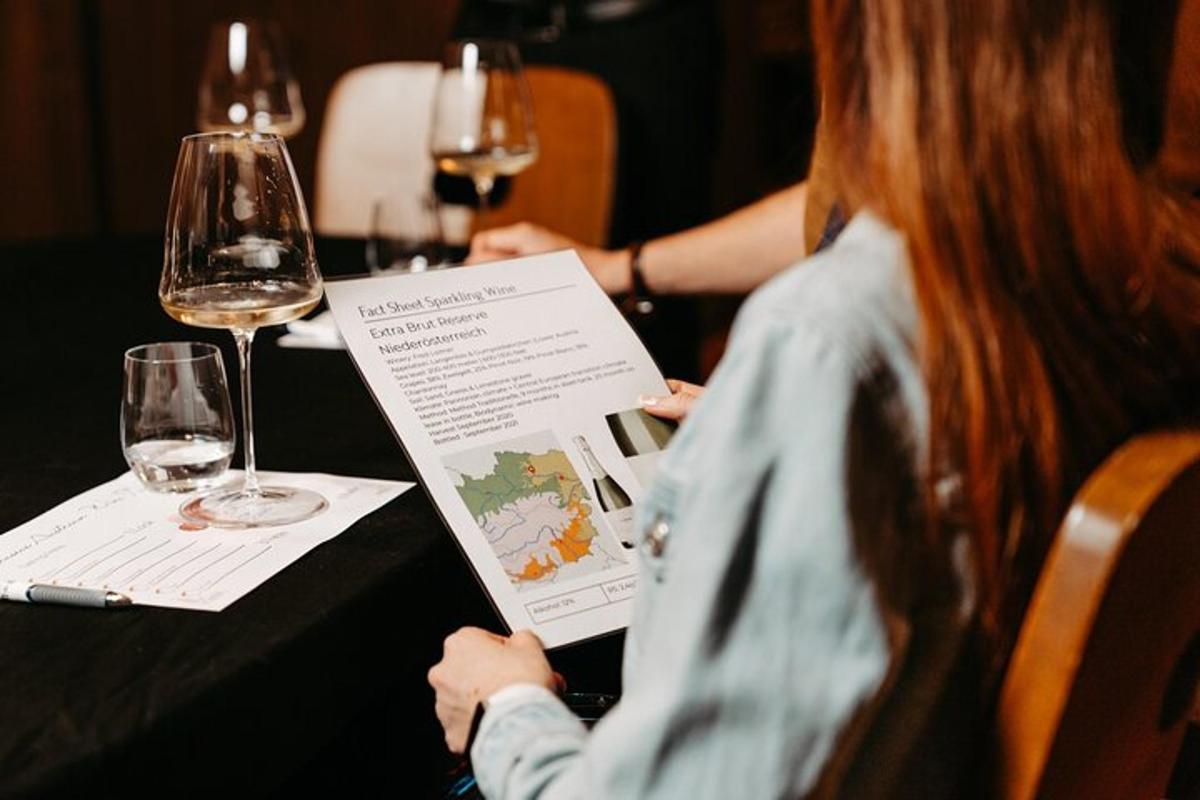 una mujer sentada en una mesa con una copa de vino