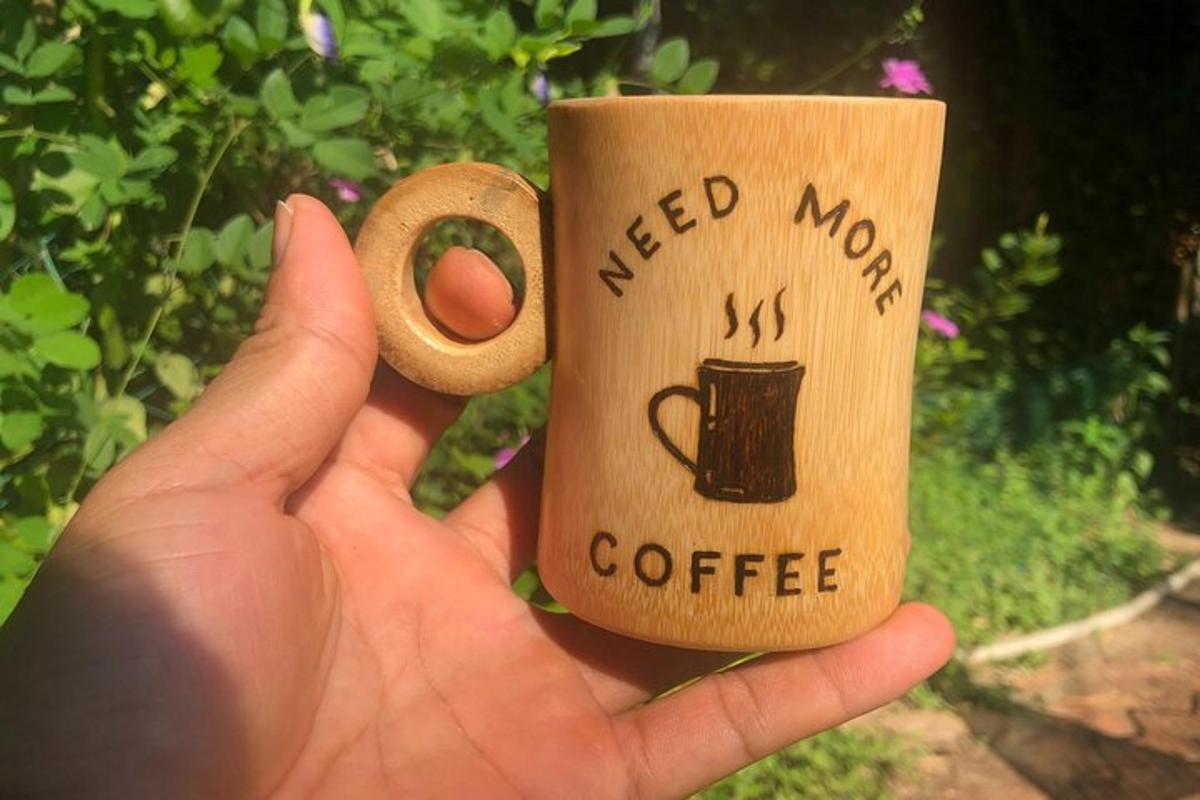 tangan yang memegang cangkir kopi kayu dengan tulisan perlu dipindahkan kopi kayu