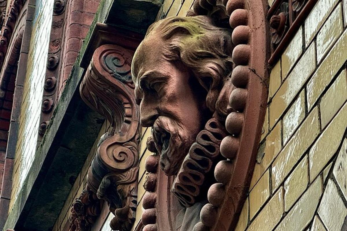 una statua di un volto sul lato di un edificio