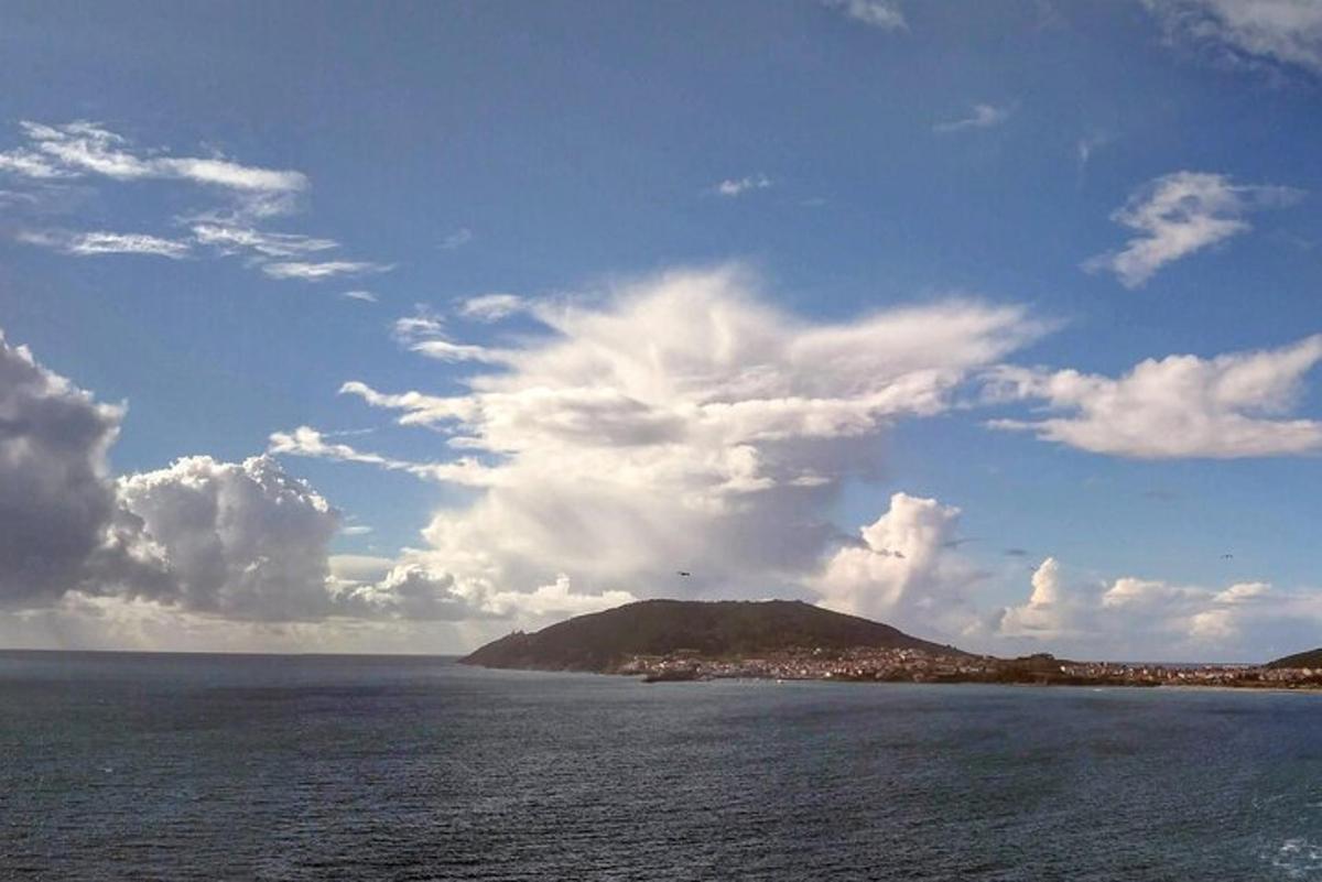 a large body of water with a hill in the distance