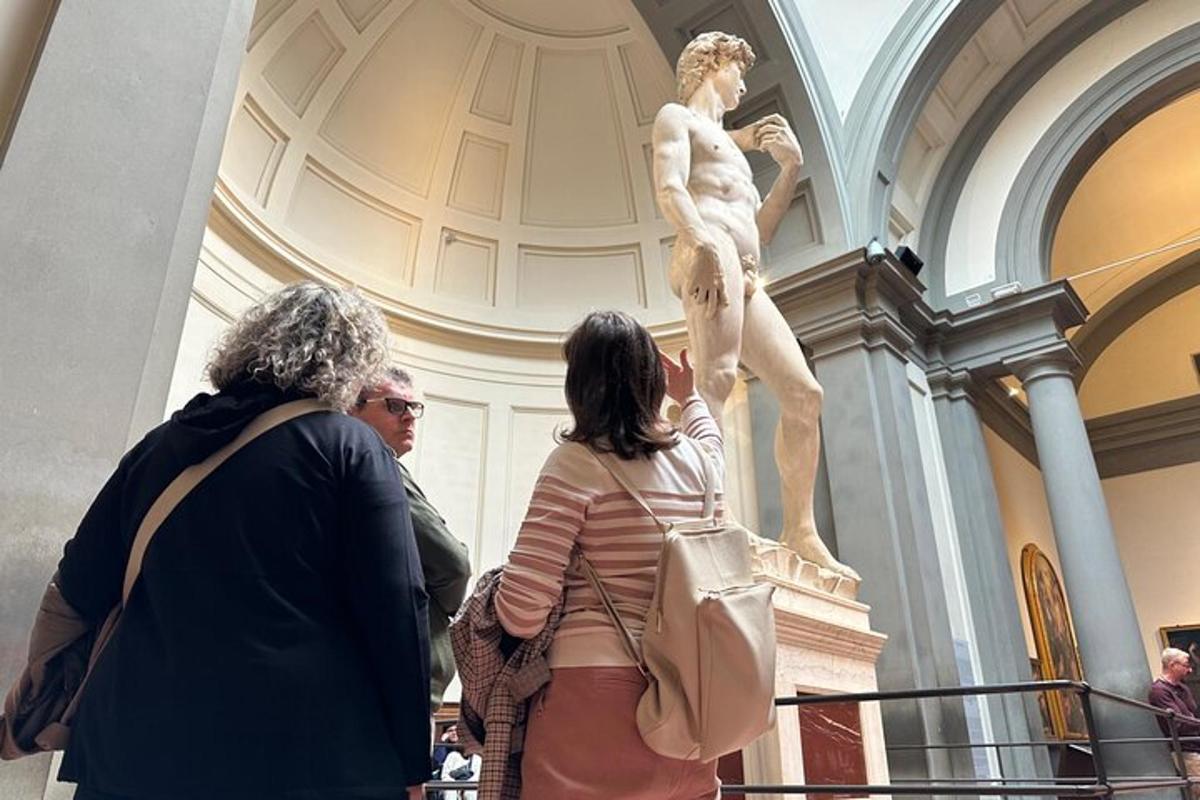 cilvēku grupa, kas muzejā aplūko statuju