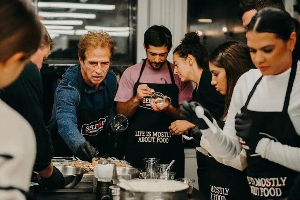 a group of people standing in a kitchen preparing food