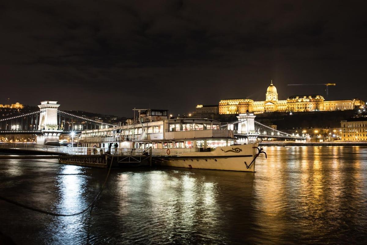 a boat docked next to a bridge at night