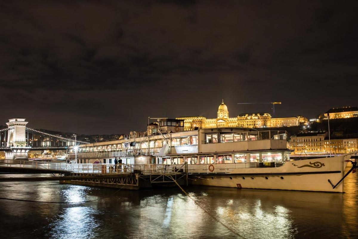 a large cruise ship docked at a pier at night